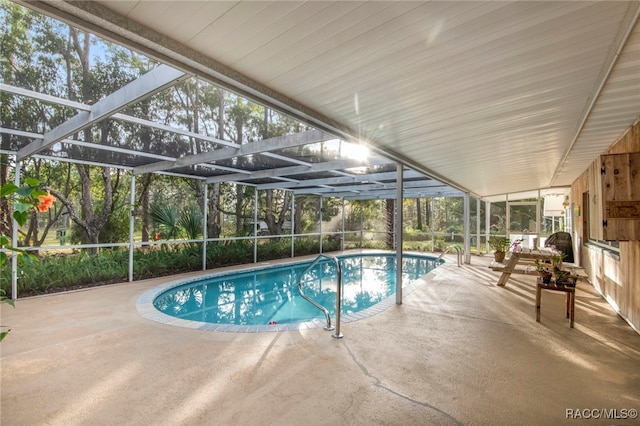 view of pool featuring glass enclosure and a patio