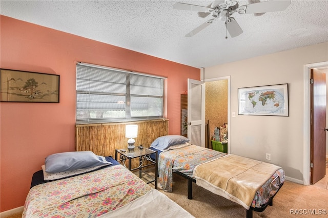 bedroom featuring a textured ceiling, ceiling fan, and light carpet