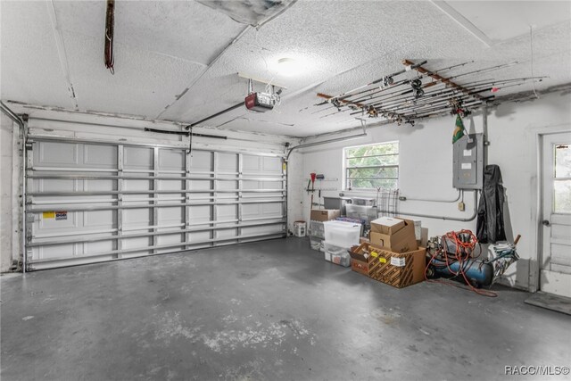 garage with electric panel and a garage door opener