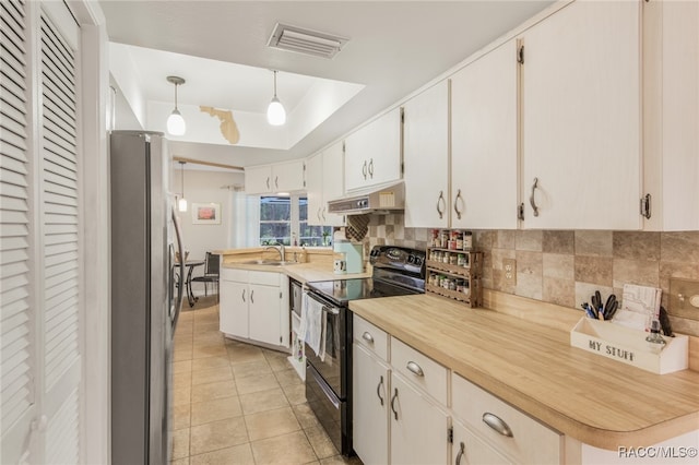 kitchen featuring white cabinets, hanging light fixtures, decorative backsplash, black / electric stove, and stainless steel refrigerator