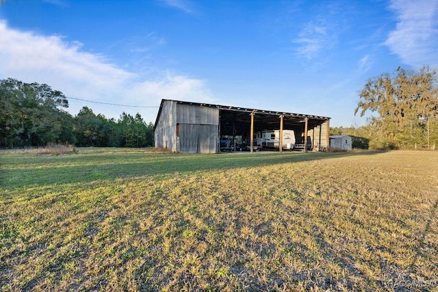 view of pole building with a carport and a yard