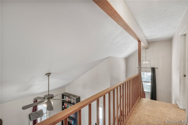 hallway featuring vaulted ceiling with beams and a textured ceiling