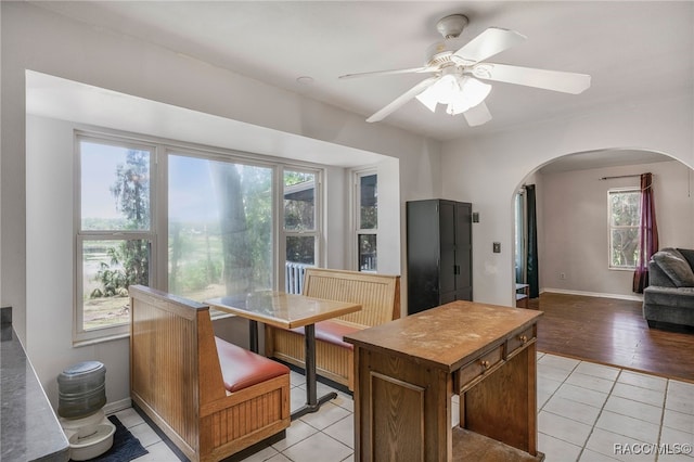 kitchen with plenty of natural light, arched walkways, a ceiling fan, and light tile patterned floors