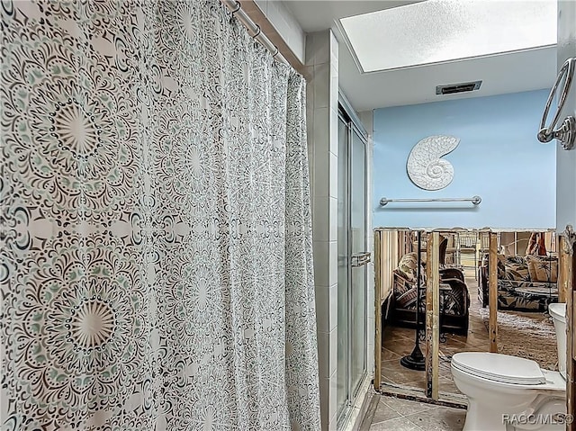 full bathroom featuring tile patterned floors, a shower stall, toilet, and visible vents