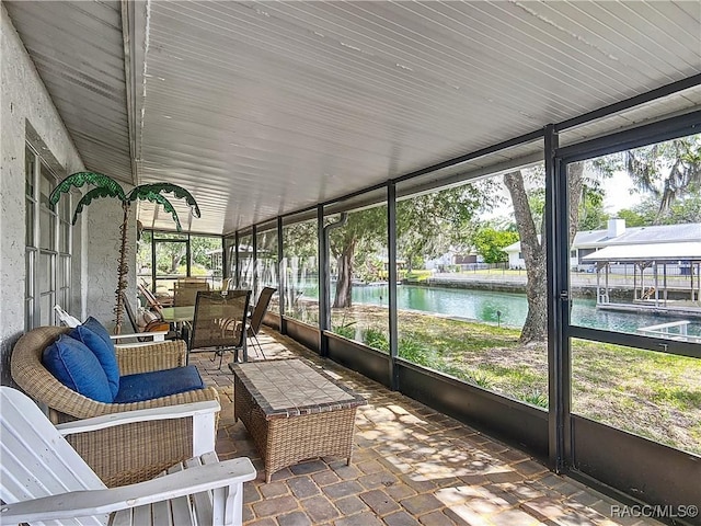 sunroom / solarium featuring a water view and outdoor dining space