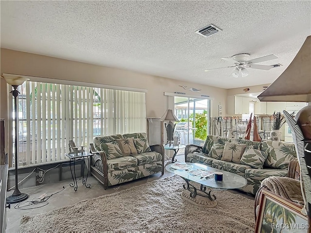living room featuring visible vents, a textured ceiling, ceiling fan, and concrete floors