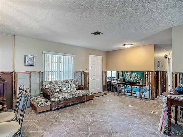 living area with a textured ceiling and visible vents