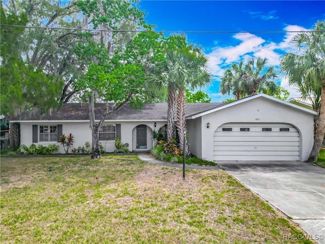 ranch-style house with an attached garage, stucco siding, a front yard, and concrete driveway