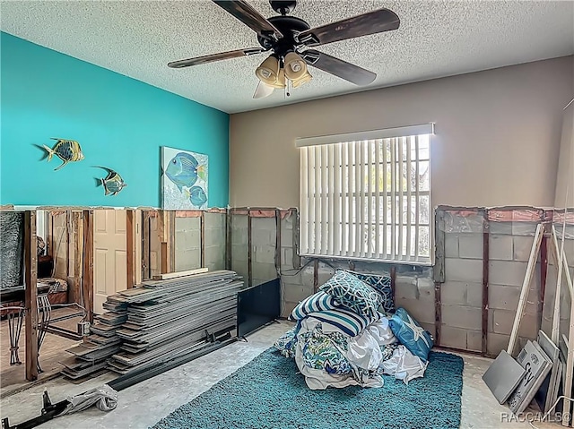 bedroom featuring a textured ceiling, concrete floors, and ceiling fan