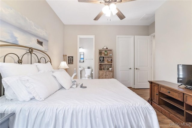 bedroom featuring dark hardwood / wood-style flooring, a closet, ceiling fan, and ensuite bathroom