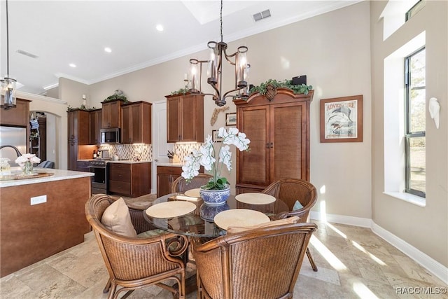 dining room with an inviting chandelier, crown molding, sink, and a wealth of natural light