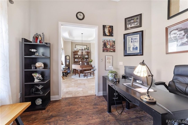 home office with dark wood-type flooring and a chandelier