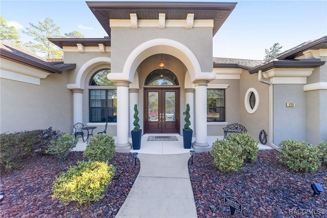 view of exterior entry with french doors and a porch