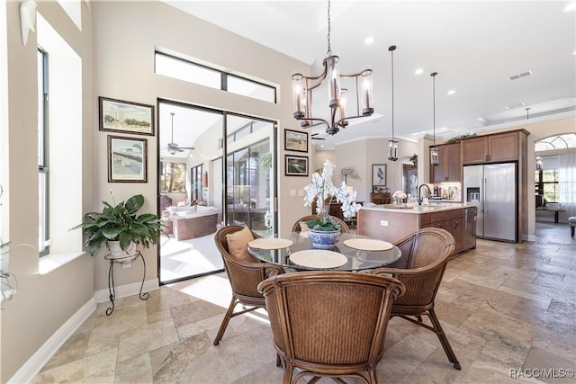 dining area featuring an inviting chandelier, ornamental molding, and sink