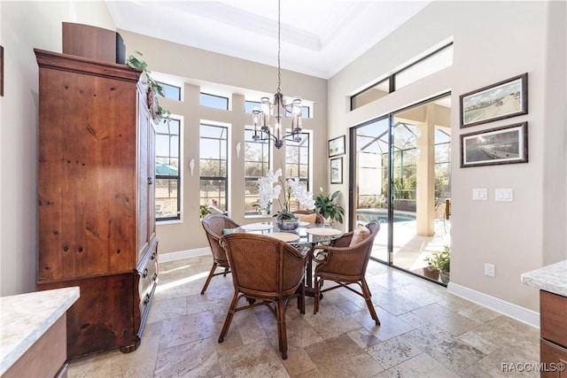 dining space featuring crown molding, plenty of natural light, a chandelier, and a tray ceiling