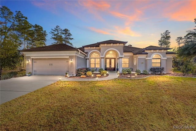 view of front facade featuring a garage and a lawn