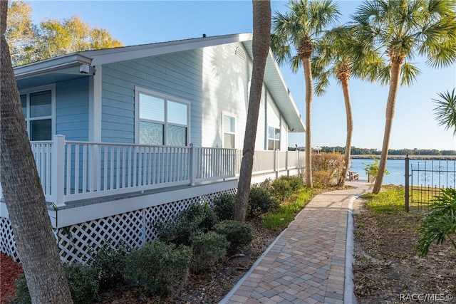 view of side of home featuring a deck with water view