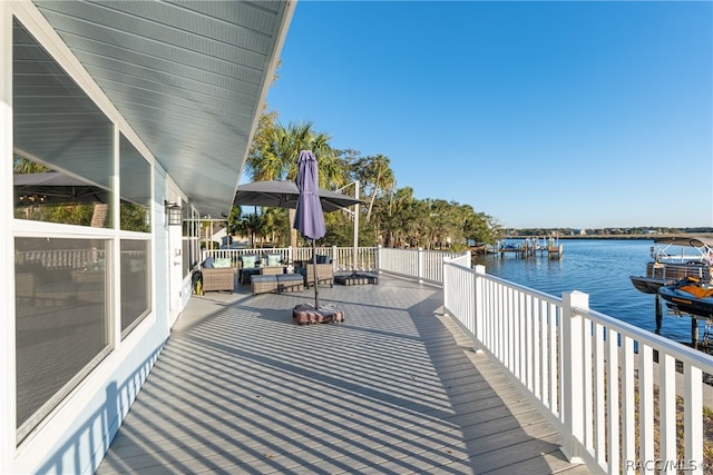 deck with an outdoor living space and a water view