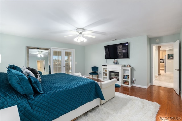 bedroom with access to exterior, hardwood / wood-style floors, french doors, and ceiling fan