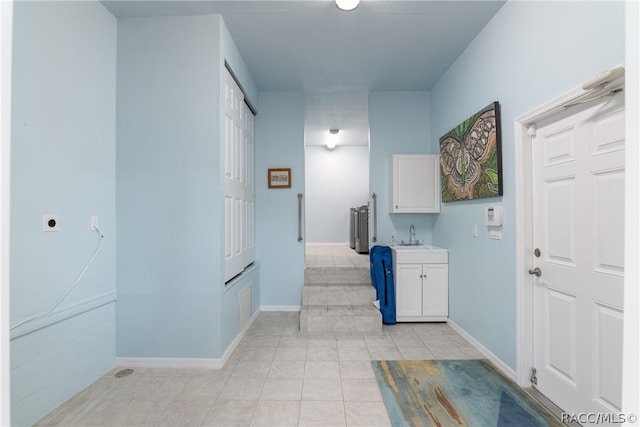 hallway with light tile patterned floors and sink