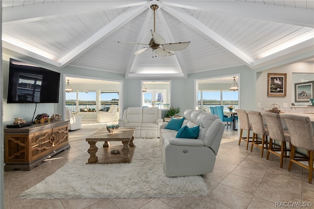 tiled living room with lofted ceiling with beams and a wealth of natural light