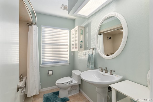 bathroom featuring tile patterned floors, toilet, and shower / bathtub combination with curtain