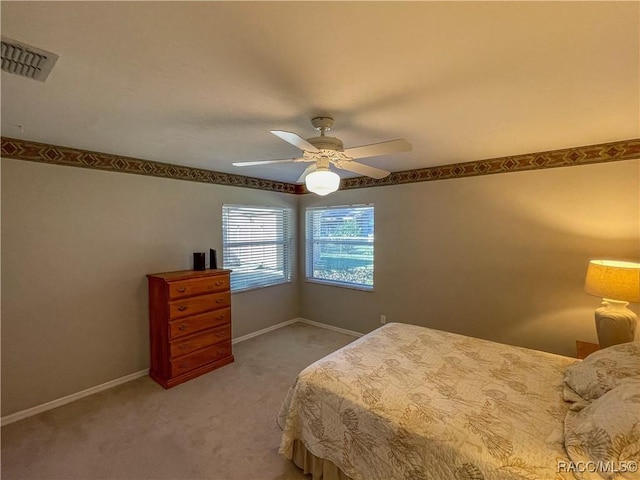 carpeted bedroom with ceiling fan, visible vents, and baseboards