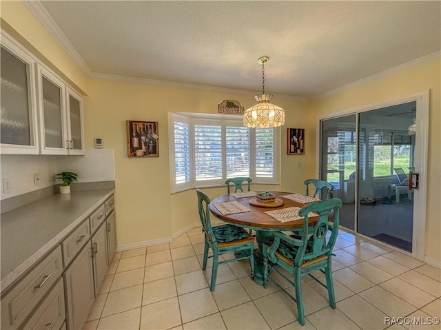 dining space with baseboards, ornamental molding, and light tile patterned flooring