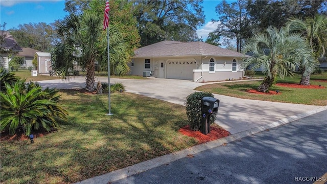 view of front of house featuring central air condition unit, stucco siding, concrete driveway, an attached garage, and a front lawn