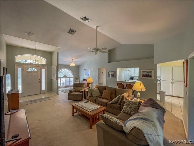 living room featuring light carpet, visible vents, high vaulted ceiling, and light tile patterned flooring