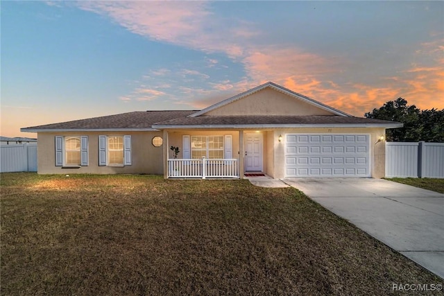 ranch-style home featuring a porch, a garage, and a lawn