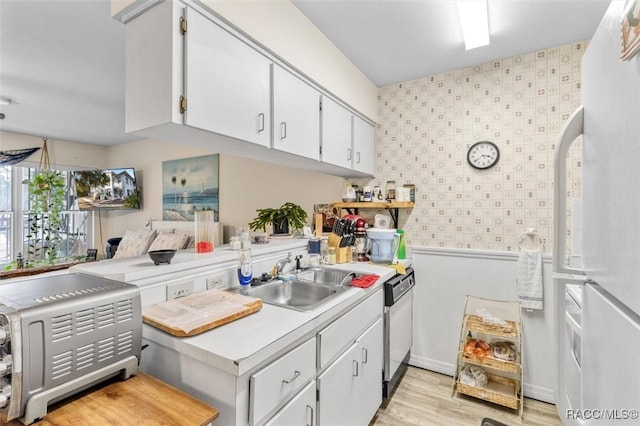 kitchen with white cabinets, dishwasher, white fridge, sink, and kitchen peninsula