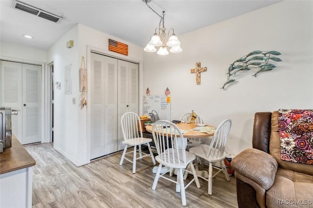 dining space featuring a chandelier and light hardwood / wood-style floors