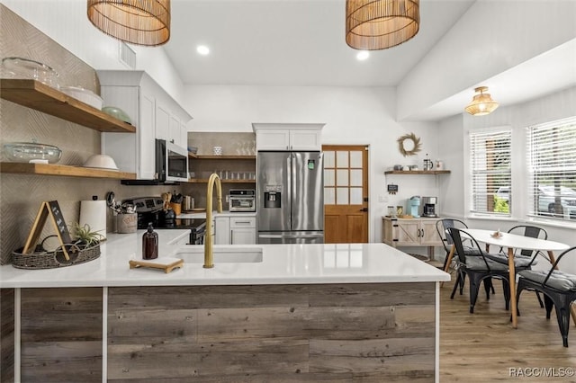 4080 N Eagle Nest Pt, Crystal River, FL 34428 - kitchen featuring open shelves, appliances with stainless steel finishes, a peninsula, light wood-style flooring, and light countertops