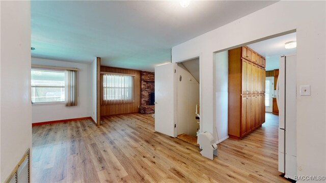 empty room with a fireplace and light wood-type flooring