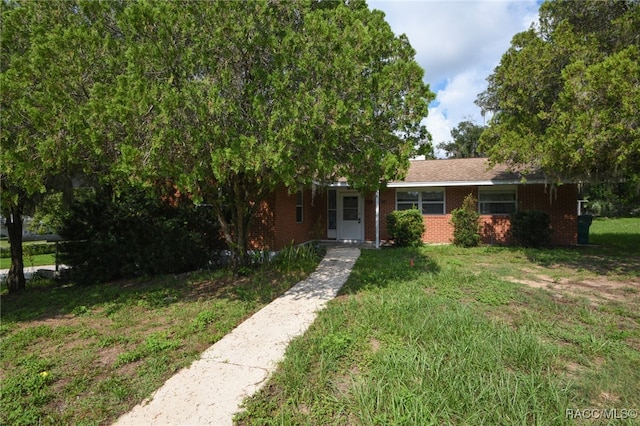 view of property hidden behind natural elements with a front yard