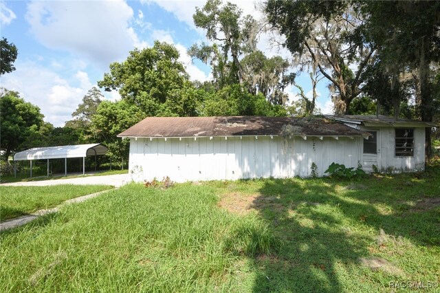 view of side of home with a yard and a carport