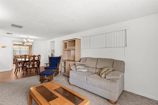 2 James St, Beverly Hills, FL 34465 - living room featuring a chandelier, wood finished floors, and a textured ceiling