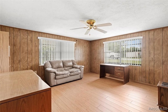 2 James St, Beverly Hills, FL 34465 - living room featuring ceiling fan, wood finished floors, and wood walls
