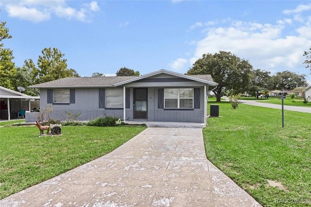 2 James St, Beverly Hills, FL 34465 - view of front of house with a front yard, brick siding, and concrete driveway