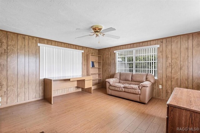 2 James St, Beverly Hills, FL 34465 - living room featuring wooden walls, hardwood / wood-style flooring, and a ceiling fan
