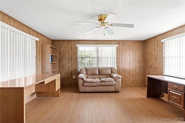 2 James St, Beverly Hills, FL 34465 - living area with light wood-style flooring, wood walls, and a ceiling fan
