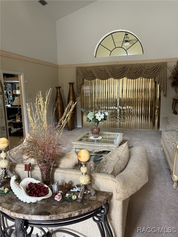 carpeted dining area featuring high vaulted ceiling