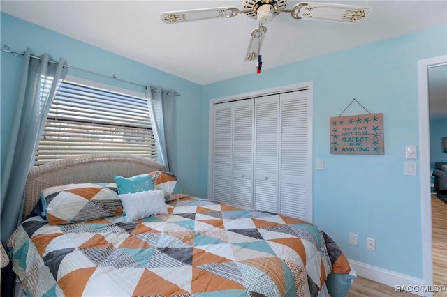 bedroom featuring a ceiling fan, a closet, baseboards, and light wood finished floors