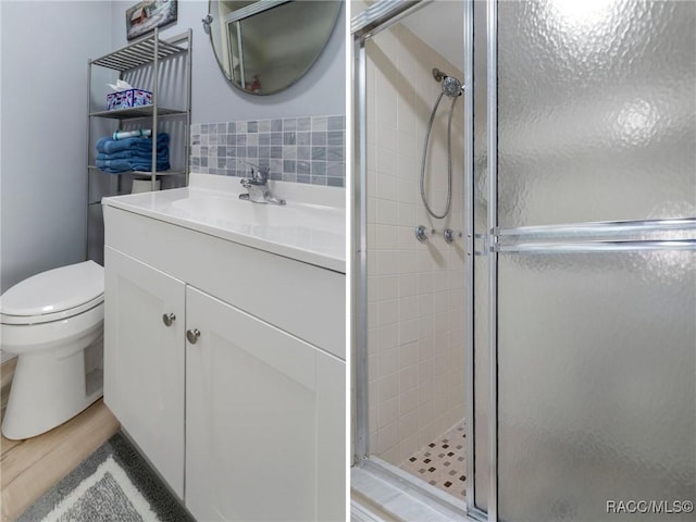 full bath featuring toilet, tasteful backsplash, a shower stall, and vanity