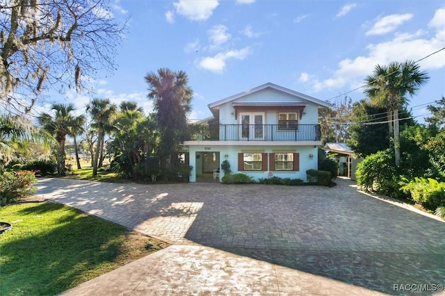 view of front facade featuring a balcony and a front lawn