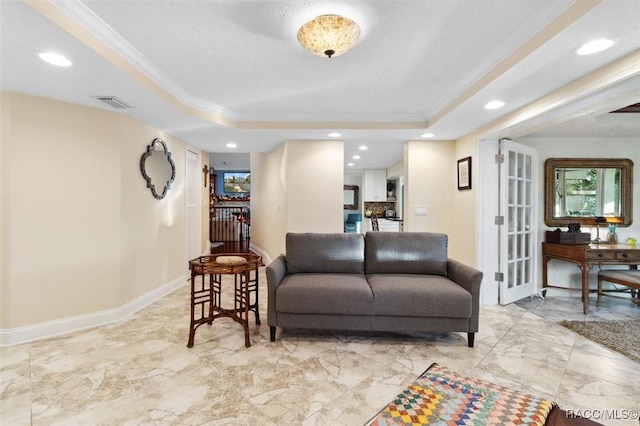 living room featuring ornamental molding and a tray ceiling