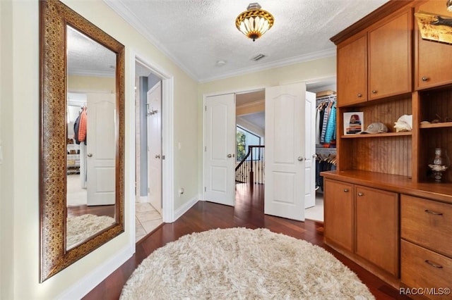 corridor featuring crown molding, dark hardwood / wood-style flooring, and a textured ceiling