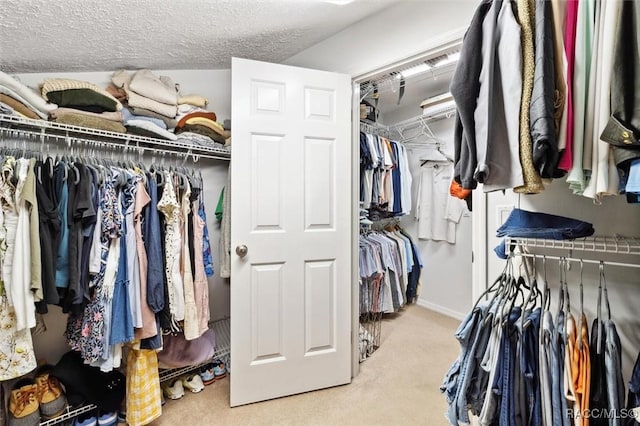 walk in closet featuring light carpet