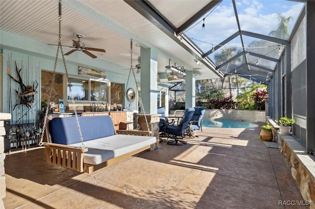 view of patio with a lanai, ceiling fan, and pool water feature